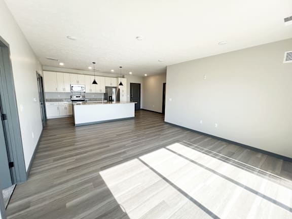 A spacious kitchen with a white countertop and a bar stool.