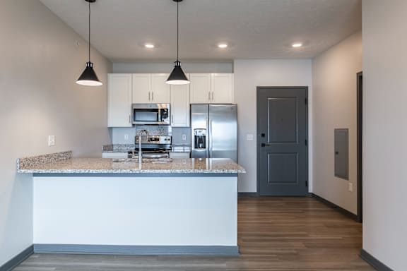 Kitchen with center island pendant lighting and stainless steel appliances at The Harbor