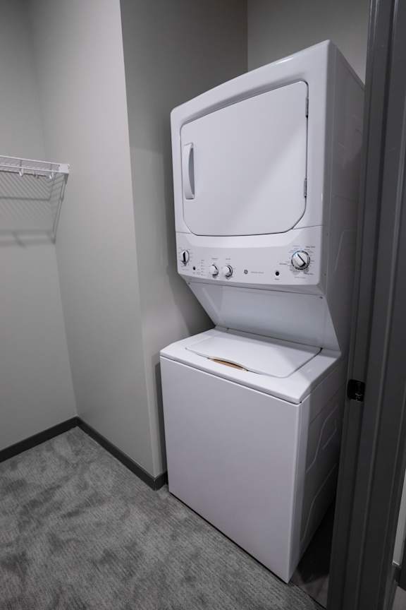 Stacked washer and dryer in a dedicated laundry area at The Harbor