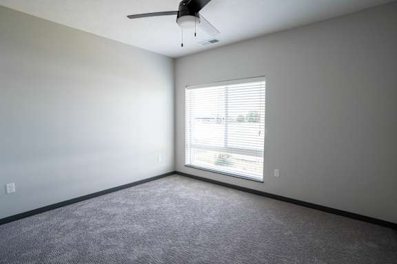 Bedroom with carpet flooring ceiling fan and a window at The Harbor