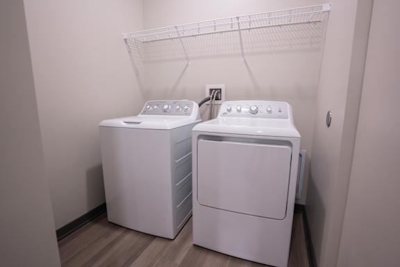 Laundry area with side by side washer and dryer inside the apartment home at The Harbor