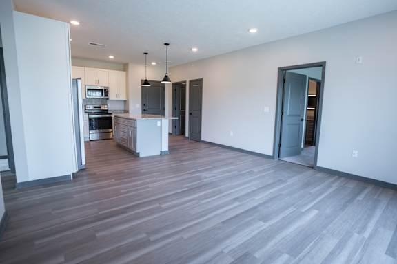 Open living area with wood style flooring and a kitchen view at The Harbor