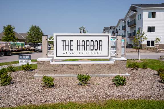 Entrance sign displaying The Harbor name with landscaped surroundings