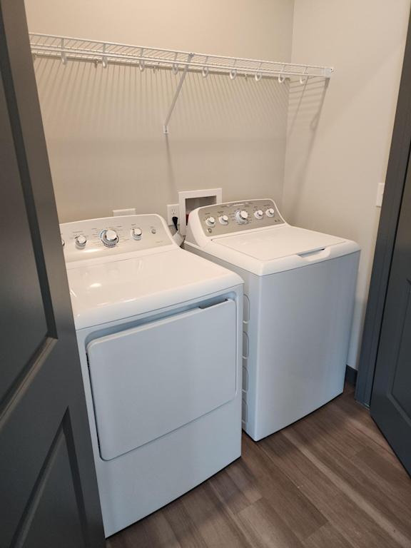 Laundry room with side by side washer and dryer and shelf above at The Harbor.