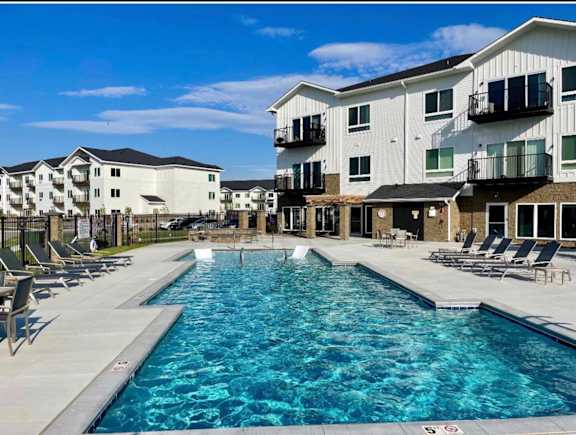 Swimming pool with surrounding apartment buildings and outdoor seating areas at The Harbor.