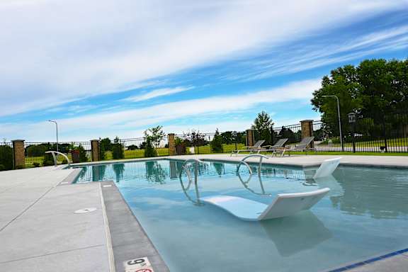 Pool deck with clear blue water and surrounding seating at The Harbor