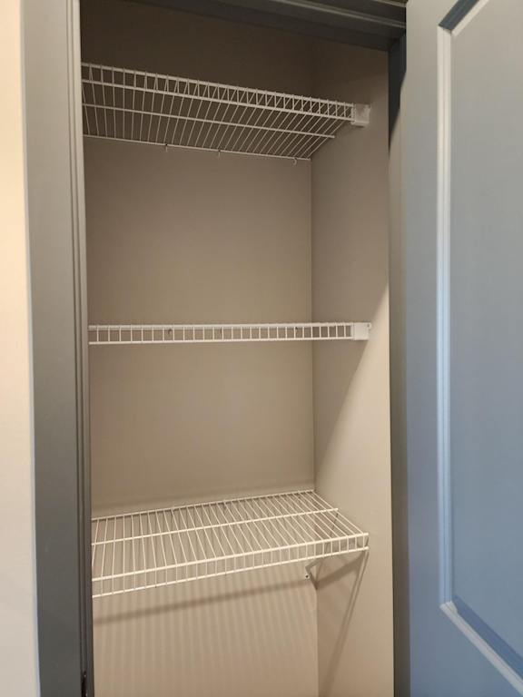 Walk in closet with multiple hanging rods wrapping around the wall at The Harbor.