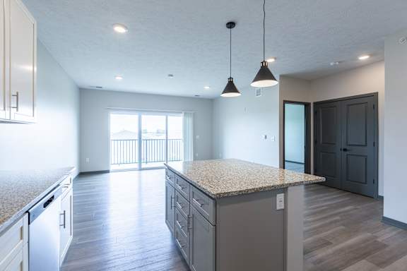 Living room with wood style flooring and sliding doors leading to outdoor space at The Harbor.