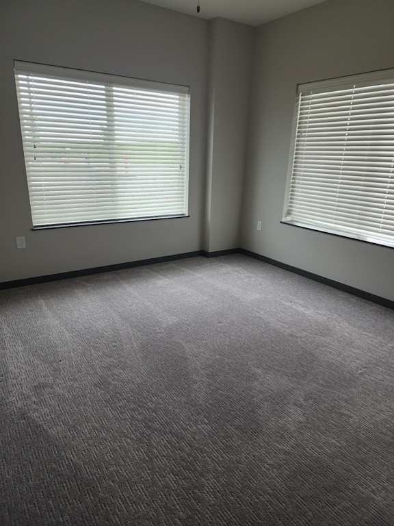 Bedroom with carpet flooring and a large window facing outdoors at The Harbor.