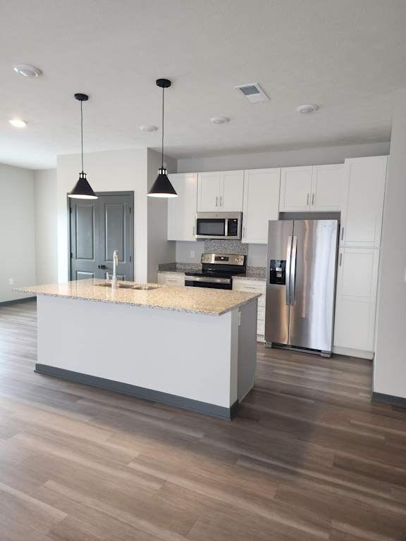 Kitchen with island and pendant lighting facing the open living space at The Harbor.