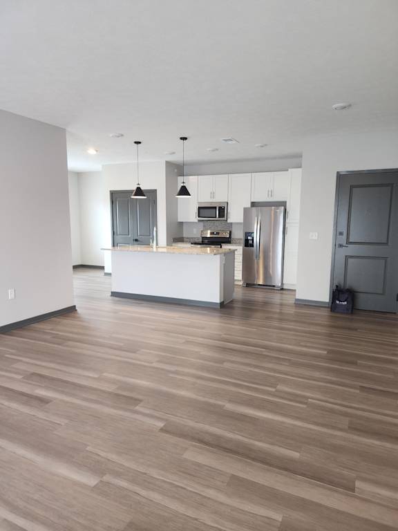 Kitchen with island, refrigerator, stove and open entryway to the living room at The Harbor.