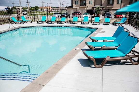 A resort-style pool with turquoise lounge chairs at The Sterling at Grand Island.