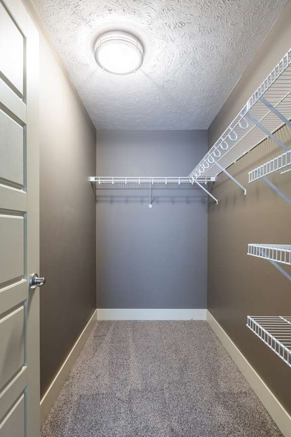 A walk-in closet with built-in shelving in the Durham home at The Sterling at Grand Island.