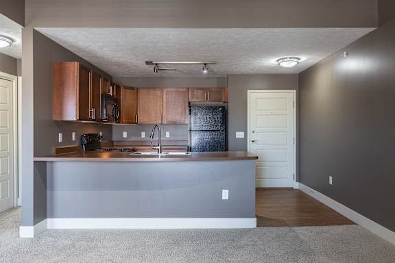 A view of the Kingston Garden Level kitchen and breakfast bar from the living area at The Sterling at Grand Island.