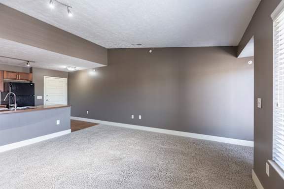 A living room with a large window providing natural light in the Kingston Garden Level home at The Sterling at Grand Island.