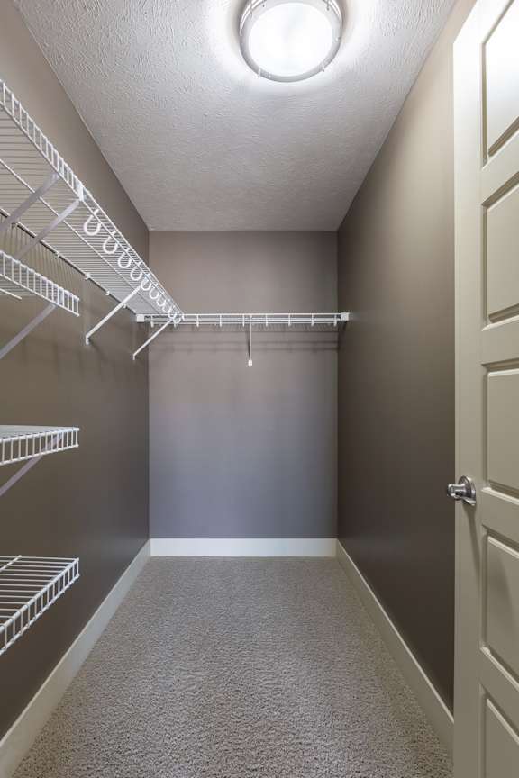 A walk in closet with shelving in the Manchester ADA home at The Sterling at Grand Island.
