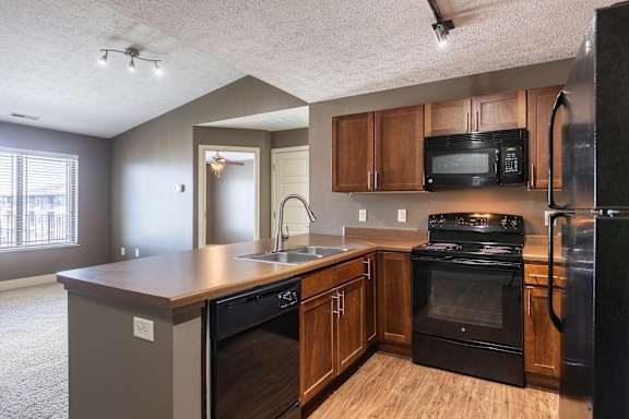 A corner angle of the kitchen featuring wood cabinetry in the Manchester ADA home at The Sterling at Grand Island.