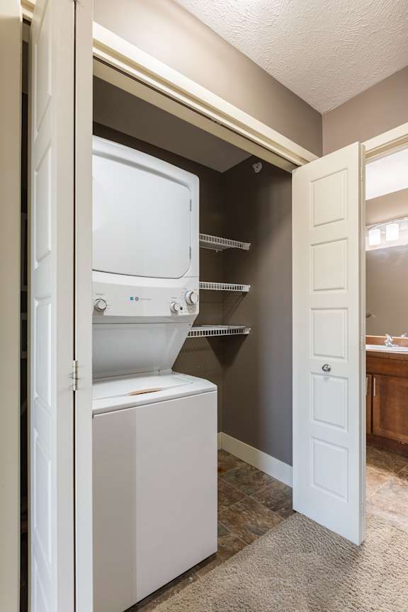 A stacked washer and dryer in the Manchester ADA home at The Sterling at Grand Island.