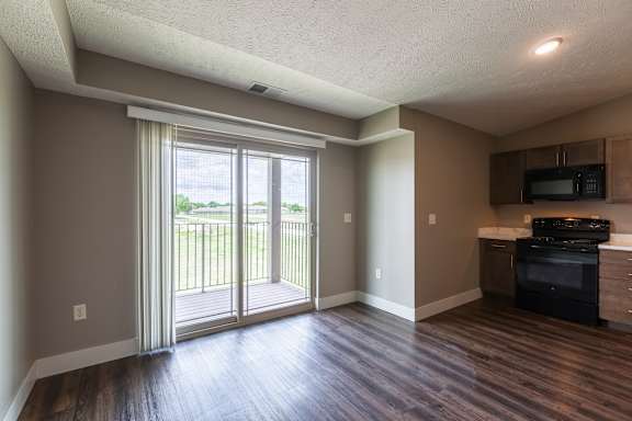 Living area with wood flooring and a sliding patio door