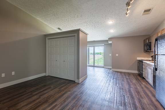 Living space with wood flooring and a large closet wall near the window