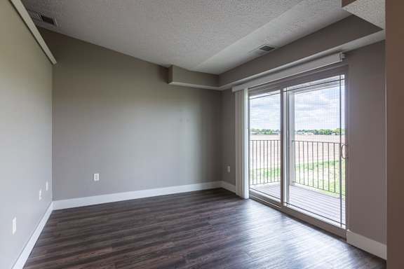Living room with wood flooring and a large window that brings in natural light