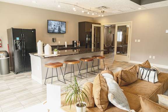 Clubhouse interior with seating tables and a television at The Sterling at Kearney