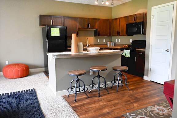 Open kitchen with dining table and chairs on wood style flooring at The Sterling at Kearney