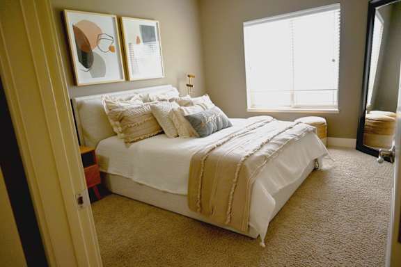 Bedroom with a bed nightstands and a window at The Sterling at Kearney
