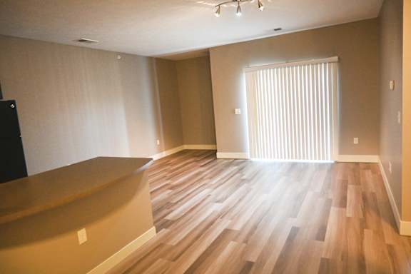 Living area with wood style flooring and large windows at The Sterling at Kearney