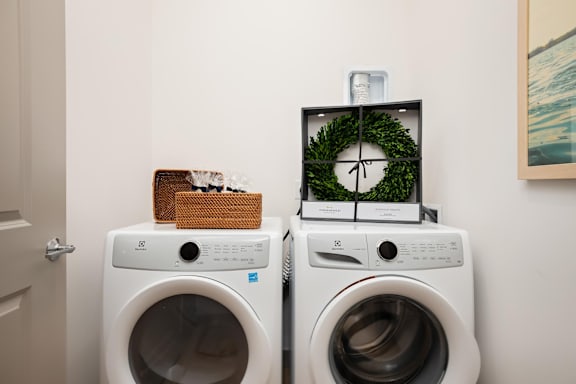 Two washing machines with a clock and a basket on top.at Converge KC Uptown, Missouri