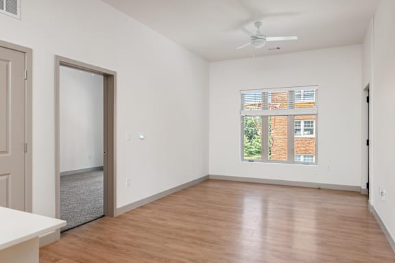 A room with a ceiling fan and a window with blinds.at Converge KC Uptown, Kansas City Missouri