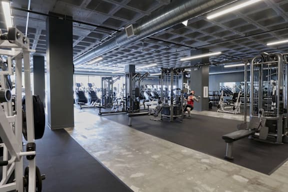 A gym with various exercise equipment and a person working out.at Converge KC Uptown, Missouri, 64111