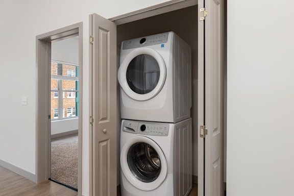 A stack of two washing machines in a cabinet.at Converge KC Uptown, Kansas City
