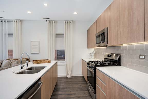 A modern kitchen with wooden cabinets and stainless steel appliances.
