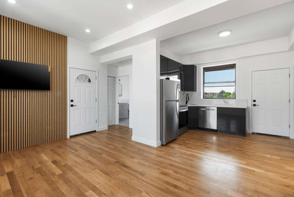 a kitchen with a stainless steel refrigerator and a wooden floor