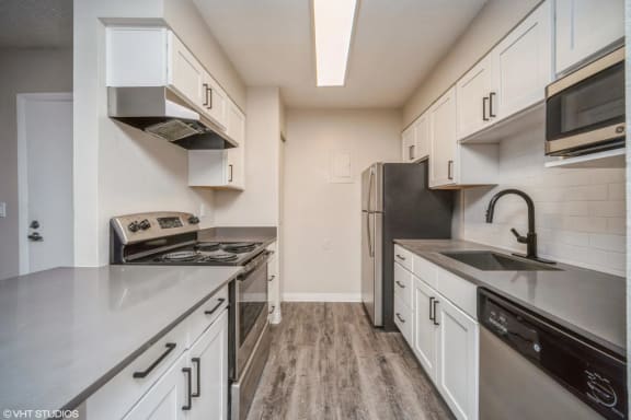 a kitchen with stainless steel appliances and white cabinets