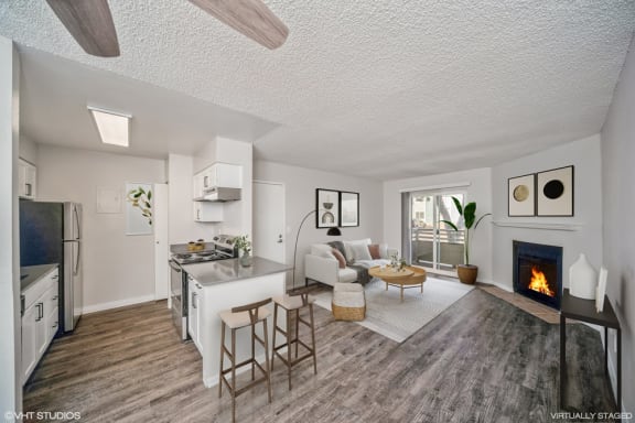 a living room with a fireplace and a kitchen with a table and chairs