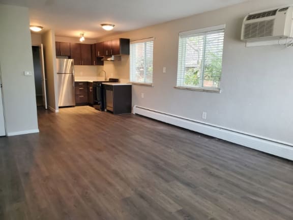 Open-concept layout with rich wood-style flooring, bright windows, and a sleek kitchen that brings the whole space together at 1444 Saint Paul St in Denver, CO