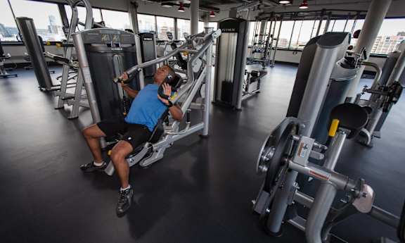 A man is working out on a leg press machine in a gym.