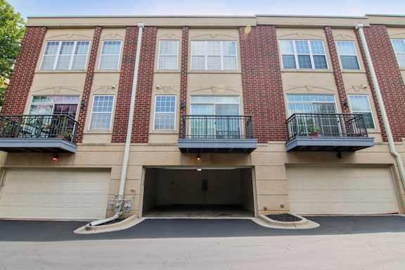 A red brick building with a garage door and balconies.