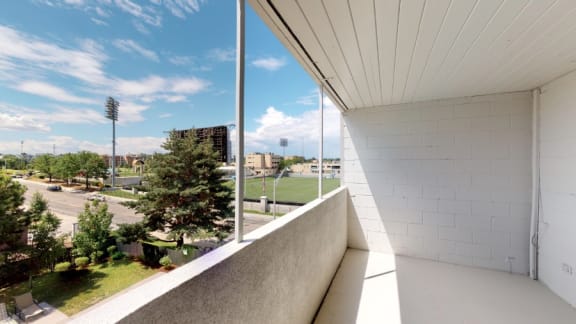 A white building with a balcony overlooking a green field at 4600 E Kentucky Ave in Denver, CO