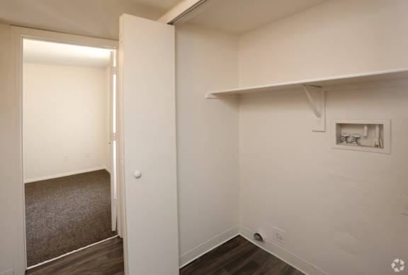A room with a white wall and a picture frame on it.