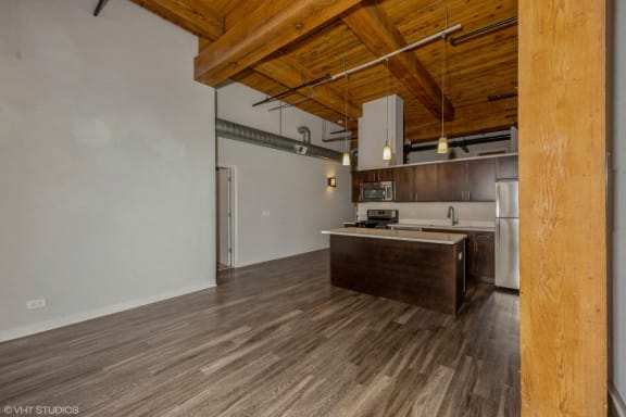 an empty kitchen with wood floors and white walls