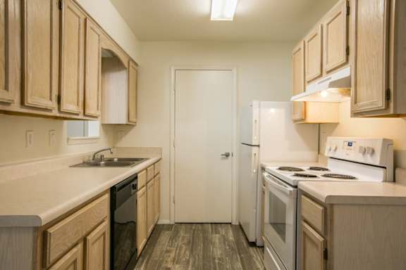 A kitchen with wooden cabinets and a white refrigerator.