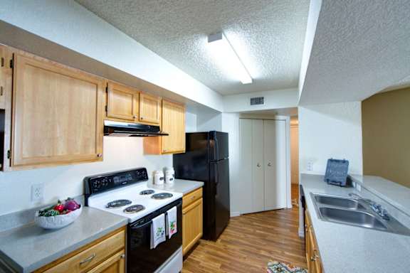 A kitchen with black appliances and wooden cabinets.