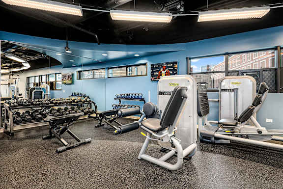 A gym with a variety of equipment including weights and machines.