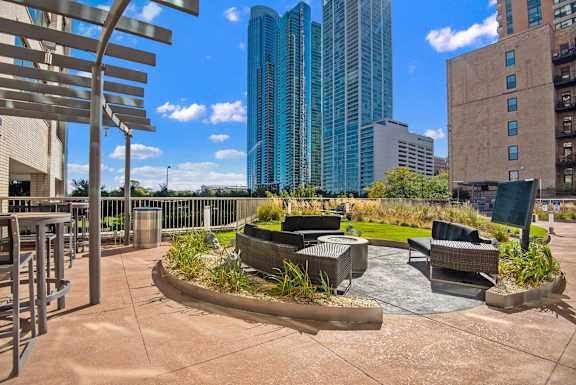 A city park with a bench and a fountain in the middle.