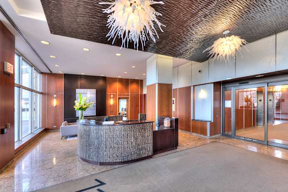A reception area with a wooden counter and a chandelier hanging from the ceiling.