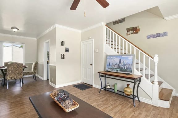 a living room with a staircase and a television