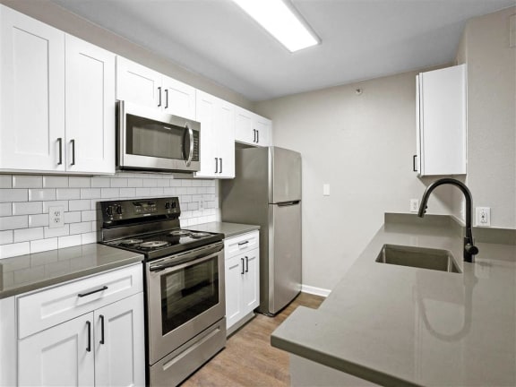 a kitchen with stainless steel appliances and white cabinets